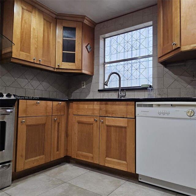 kitchen with sink, light tile patterned floors, dishwasher, stainless steel stove, and decorative backsplash