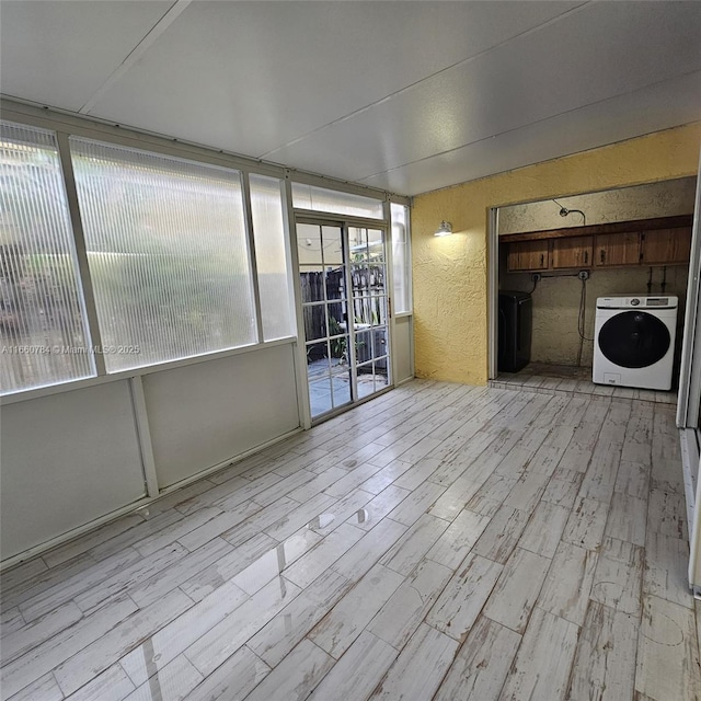1182 W 37th Ter Unit 11, Hialeah, FL 33012 - unfurnished living room featuring washer / dryer, a textured wall, and wood finished floors