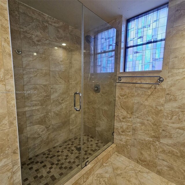 bathroom featuring a shower with door