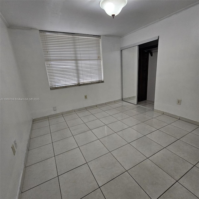 unfurnished bedroom with light tile patterned flooring and a closet