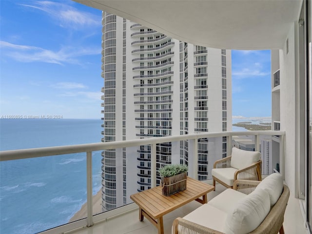 balcony featuring a beach view and a water view