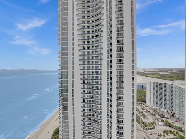 view of building exterior featuring a view of the beach and a water view