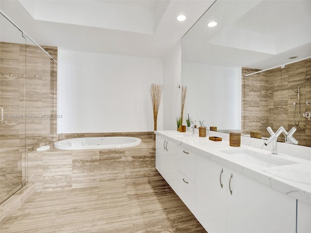 bathroom featuring shower with separate bathtub, a tray ceiling, and vanity