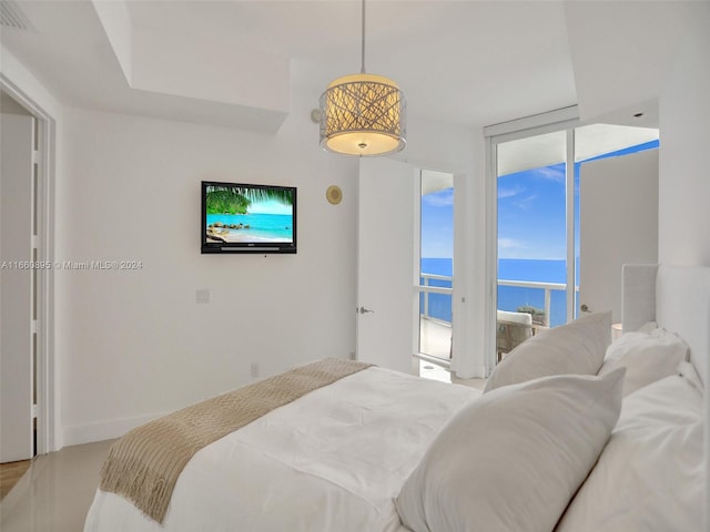 bedroom with floor to ceiling windows, access to exterior, and hardwood / wood-style floors