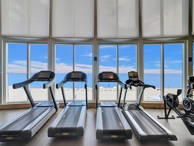 gym with expansive windows and a water view