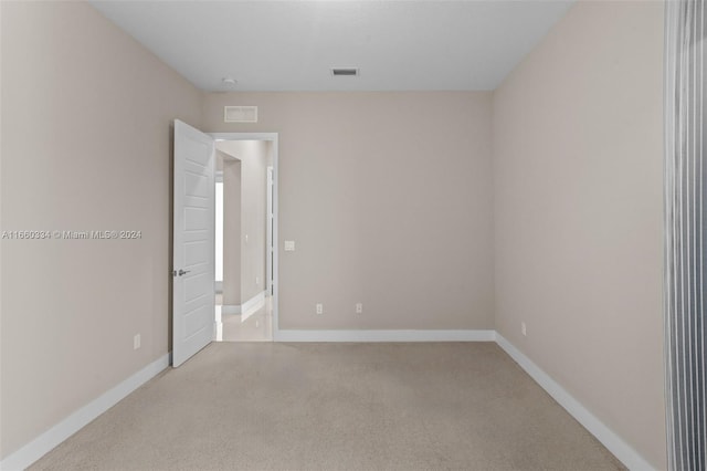 spare room featuring light colored carpet