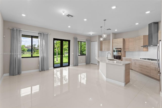 kitchen featuring pendant lighting, light tile patterned flooring, an island with sink, stainless steel appliances, and light brown cabinets