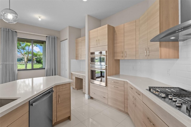 kitchen featuring hanging light fixtures, light tile patterned floors, wall chimney exhaust hood, appliances with stainless steel finishes, and light brown cabinetry