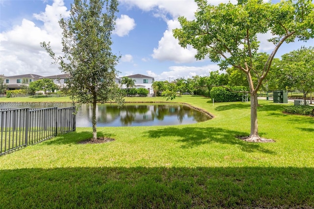 surrounding community featuring a lawn and a water view