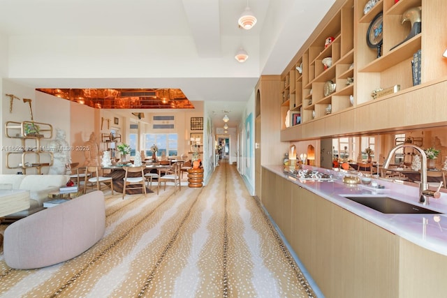 interior space with modern cabinets, beam ceiling, light countertops, and a sink