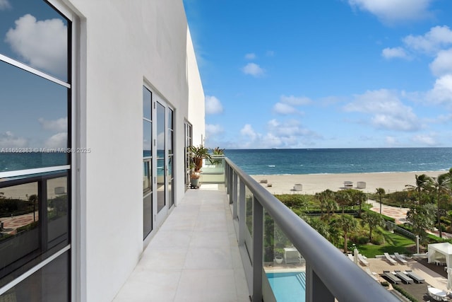 balcony featuring a water view and a beach view