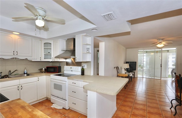 kitchen featuring white cabinets, ceiling fan, electric range, and kitchen peninsula