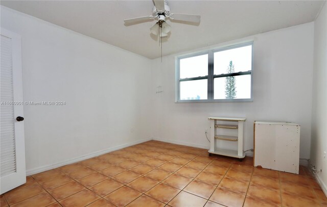 spare room with ceiling fan and light tile patterned floors