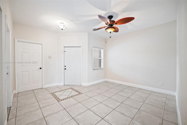 unfurnished room featuring ceiling fan, light tile patterned floors, and a textured ceiling