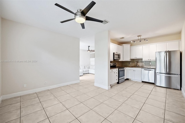 kitchen featuring sink, light tile patterned floors, backsplash, white cabinetry, and appliances with stainless steel finishes