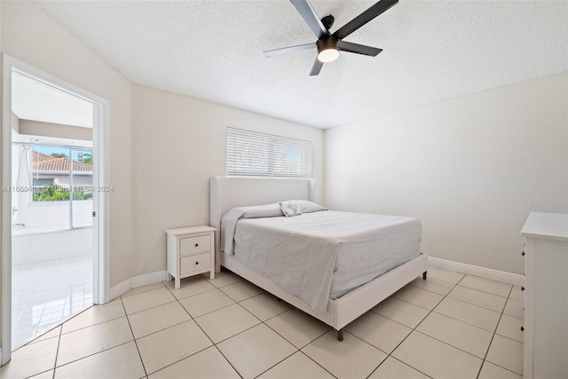 tiled bedroom with ceiling fan and a textured ceiling