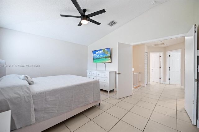 bedroom featuring a textured ceiling, light tile patterned floors, lofted ceiling, and ceiling fan