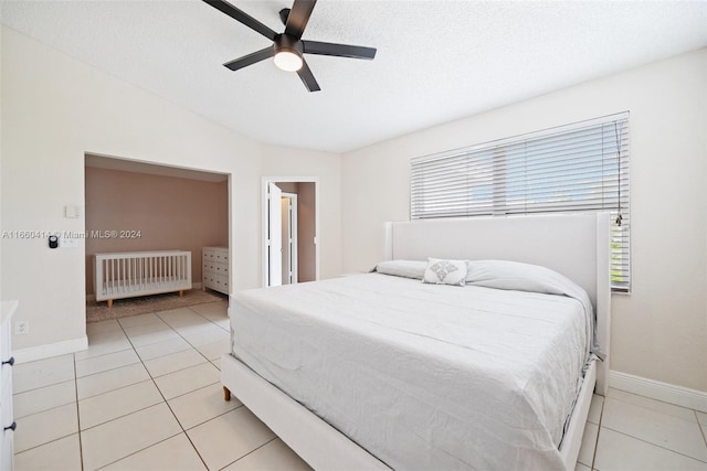 tiled bedroom featuring radiator heating unit, vaulted ceiling, ceiling fan, and a textured ceiling