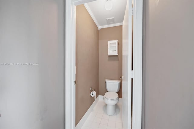 bathroom with crown molding, toilet, and tile patterned flooring