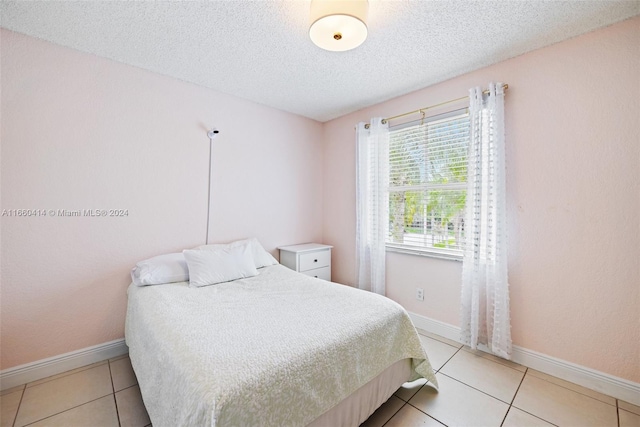 bedroom featuring a textured ceiling and light tile patterned flooring