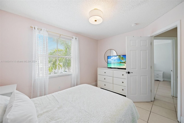 bedroom with a textured ceiling and light tile patterned floors