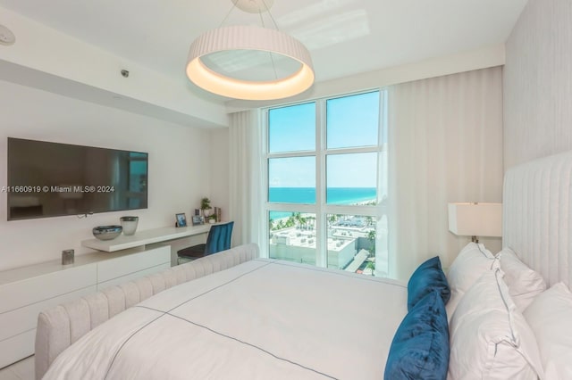 bedroom with multiple windows and a water view