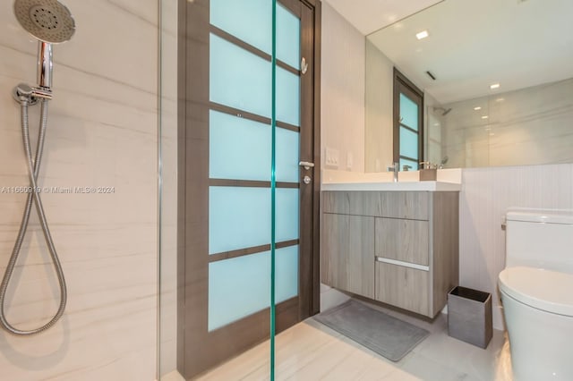 bathroom featuring tiled shower, vanity, and toilet