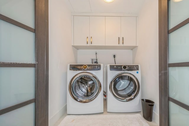 washroom featuring washing machine and dryer and cabinets