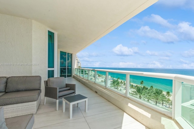 balcony featuring a view of the beach and a water view