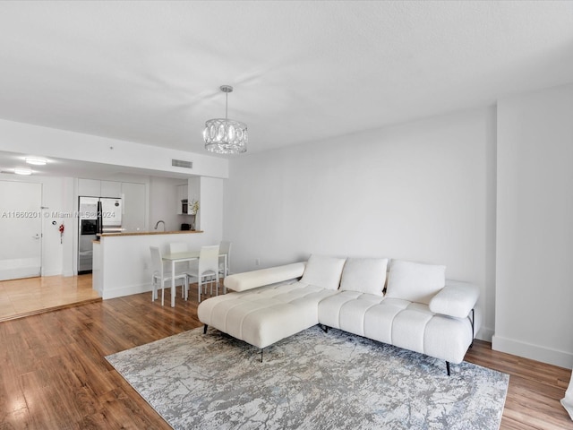 living room with hardwood / wood-style floors and a notable chandelier