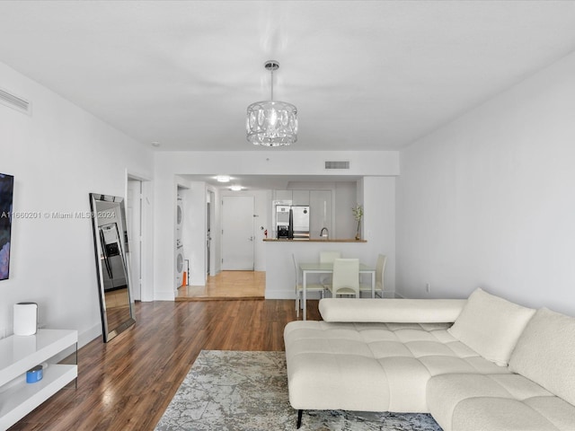 living room featuring dark hardwood / wood-style floors and an inviting chandelier