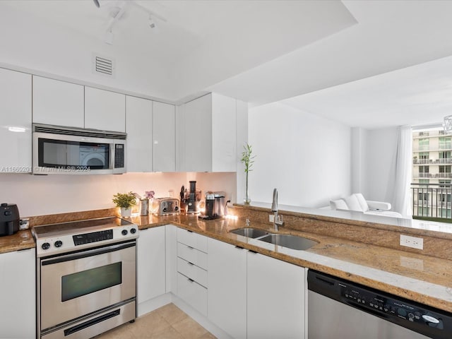 kitchen with white cabinets, sink, light tile patterned flooring, light stone counters, and stainless steel appliances