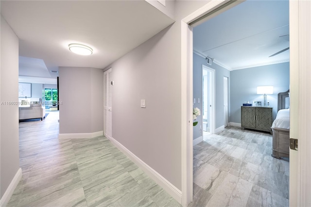 corridor featuring ornamental molding and light hardwood / wood-style floors