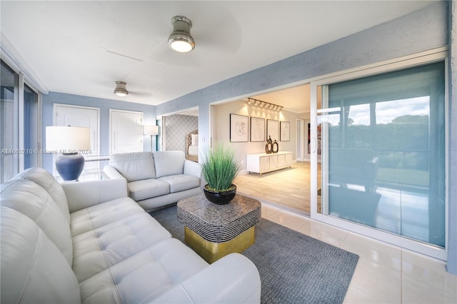 living room featuring light wood-type flooring, ceiling fan, and plenty of natural light