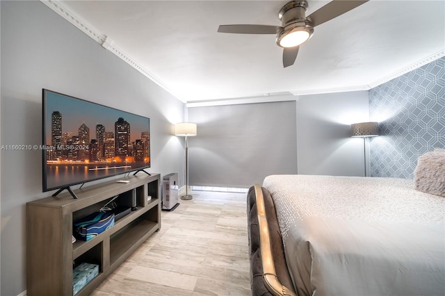 bedroom featuring light hardwood / wood-style flooring, ceiling fan, and crown molding