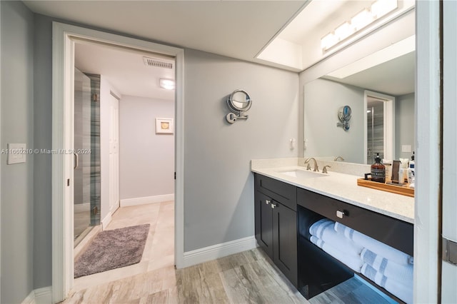 bathroom with walk in shower, wood-type flooring, and vanity