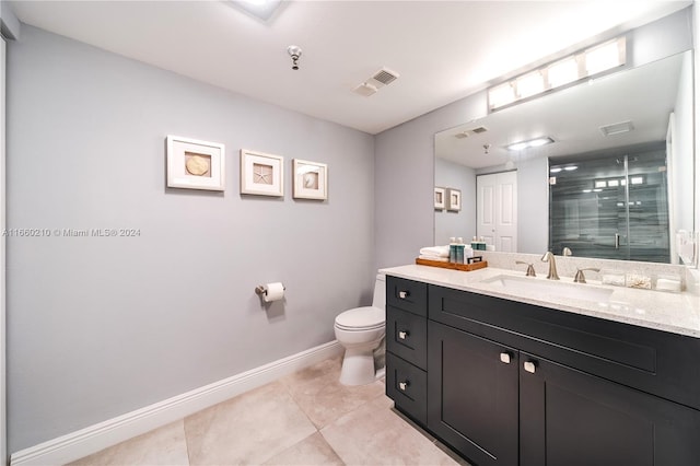 bathroom with tile patterned flooring, vanity, toilet, and an enclosed shower