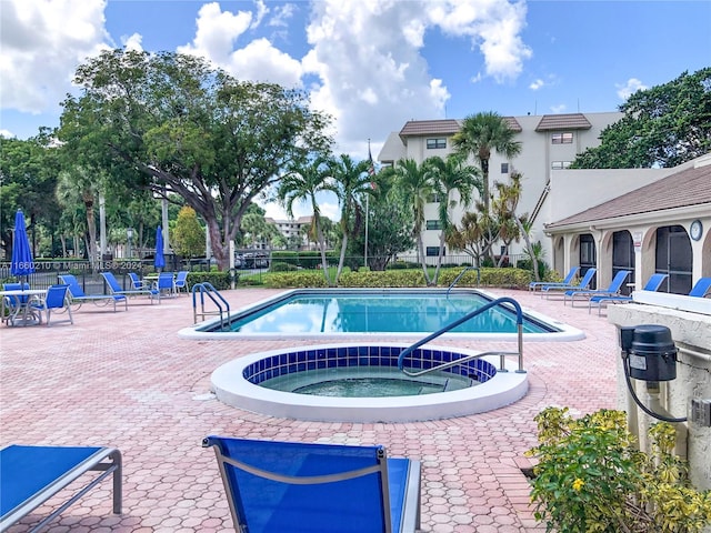 view of swimming pool with a community hot tub and a patio area