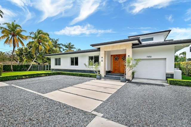 view of front of property featuring fence, driveway, and stucco siding