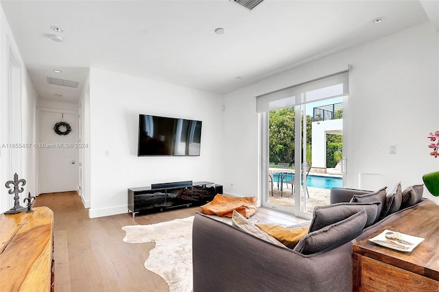 living area featuring light wood-style flooring, recessed lighting, and baseboards