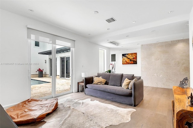 living room with light wood finished floors, visible vents, and recessed lighting