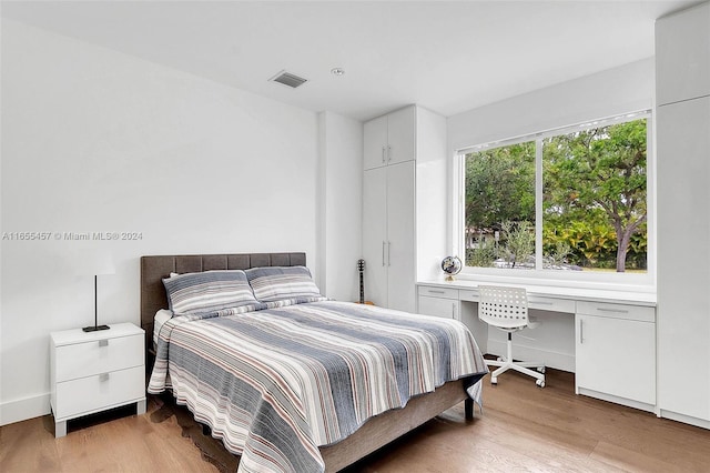 bedroom with visible vents and wood finished floors