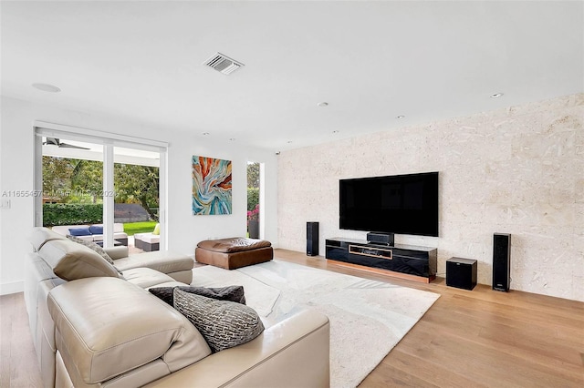 living room featuring ceiling fan and light wood-type flooring