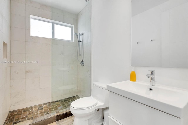bathroom with a walk in shower, vanity, and toilet