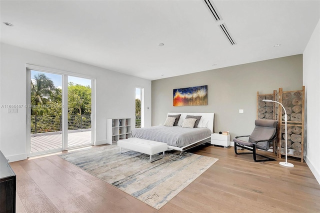 bedroom featuring access to outside, baseboards, and wood finished floors