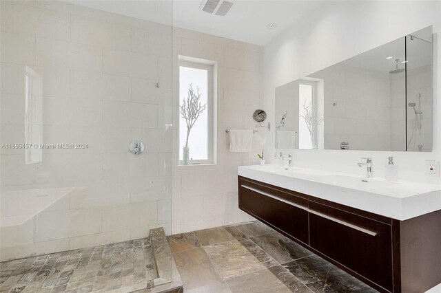 bathroom featuring tiled shower and vanity