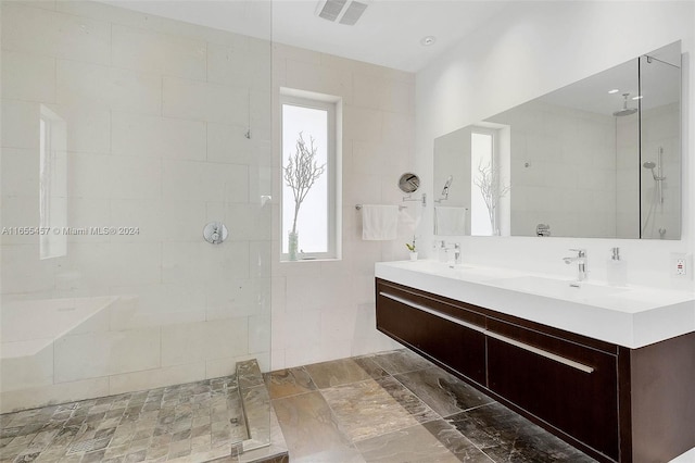 full bath with a sink, visible vents, a walk in shower, and double vanity