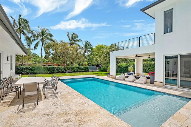 view of swimming pool with a yard, outdoor dining space, a ceiling fan, and a patio