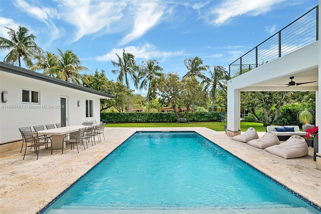 view of swimming pool with a ceiling fan, outdoor dining space, a patio, an outdoor hangout area, and a fenced in pool