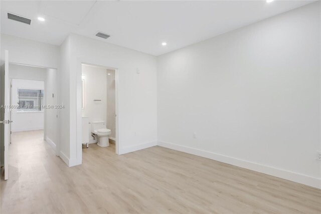 unfurnished bedroom featuring light hardwood / wood-style flooring and ensuite bath